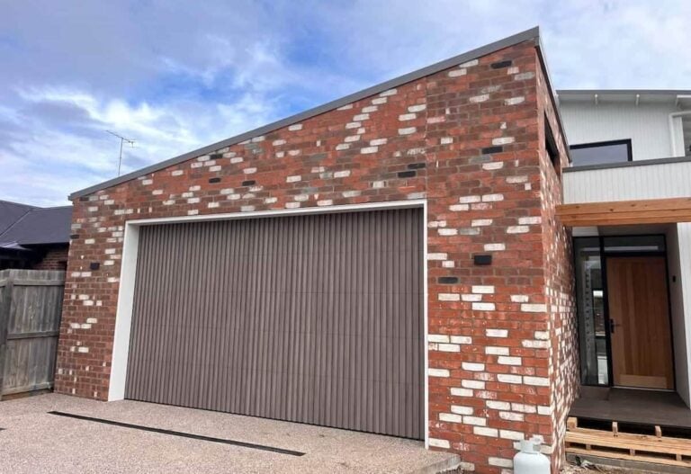 Danmar custom sectional garage door clad in Deco weathered timber battens, installed on a coastal home in Ocean Grove with materials and finishes suited to coastal conditions.