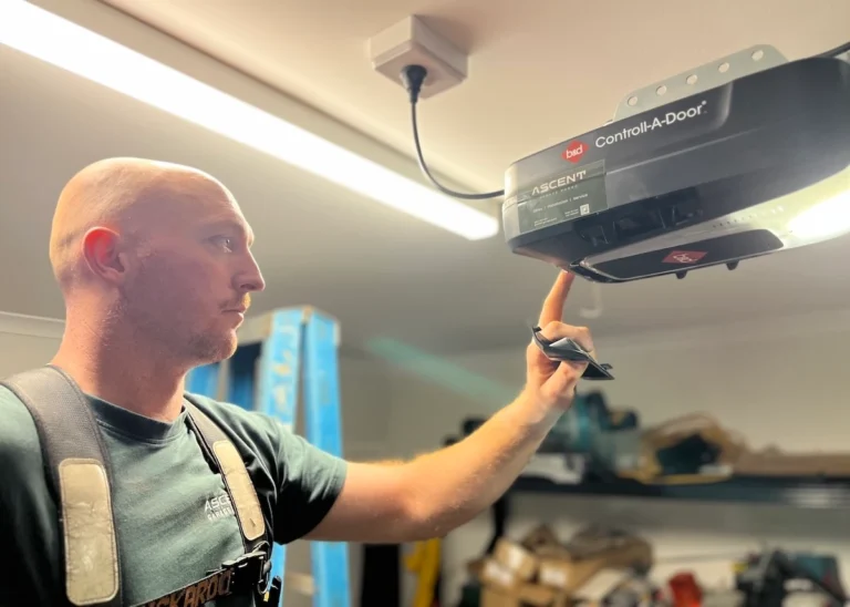 Garage door technician inspecting a B&D Control-A-Door opener while troubleshooting a garage door that won't open in a residential garage.