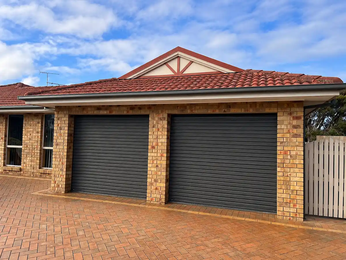 Two B&D Roll-A-Door Deluxe roller garage doors featuring a Deluxe Curtain profile in COLORBOND Woodland Grey, professionally installed with a Power Drive opener in Geelong by Ascent Garage Doors.