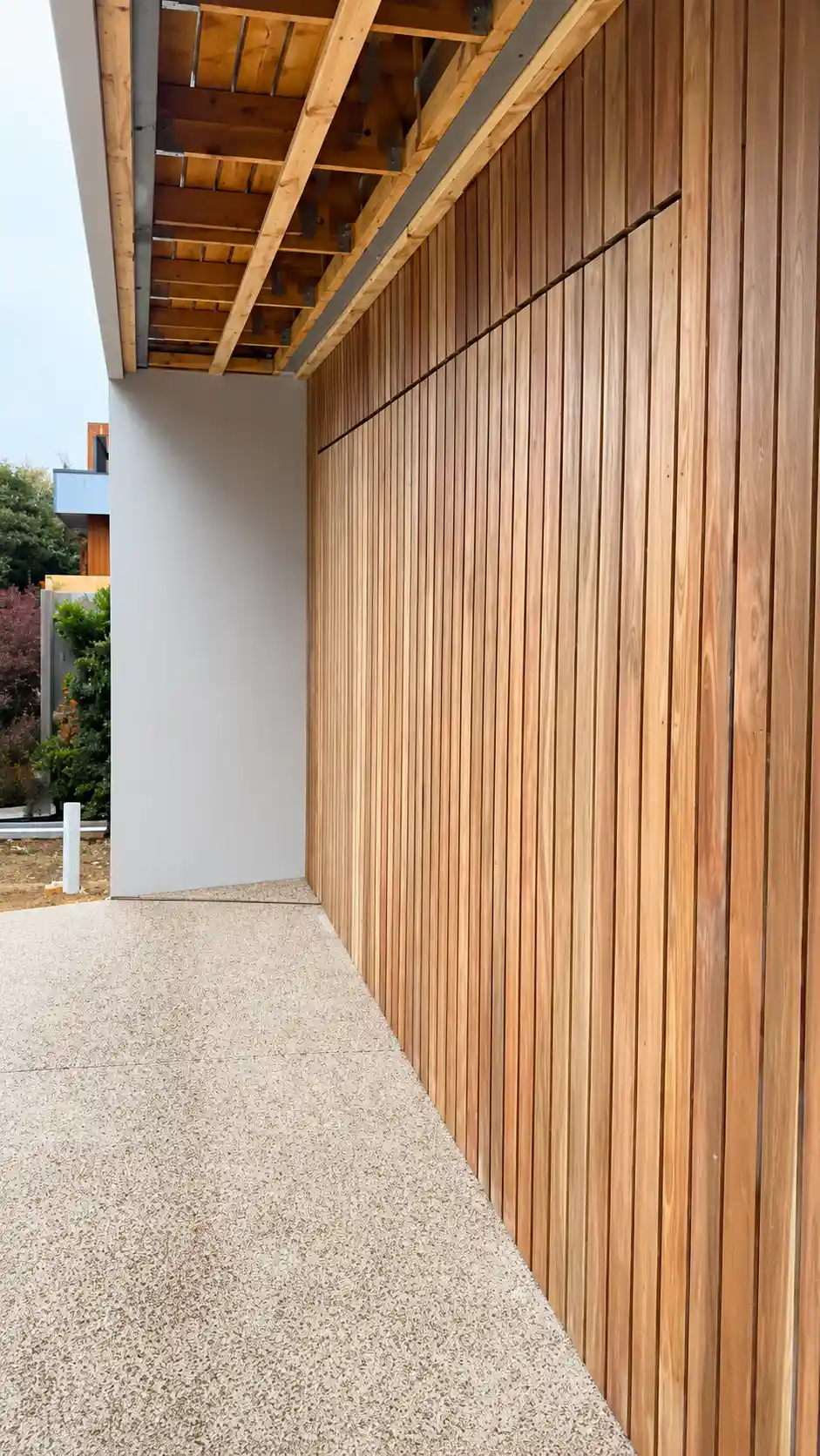 Custom architectural tilt garage door with timber cladding on a modern home in Torquay, Victoria, installed by Ascent Garage Doors.