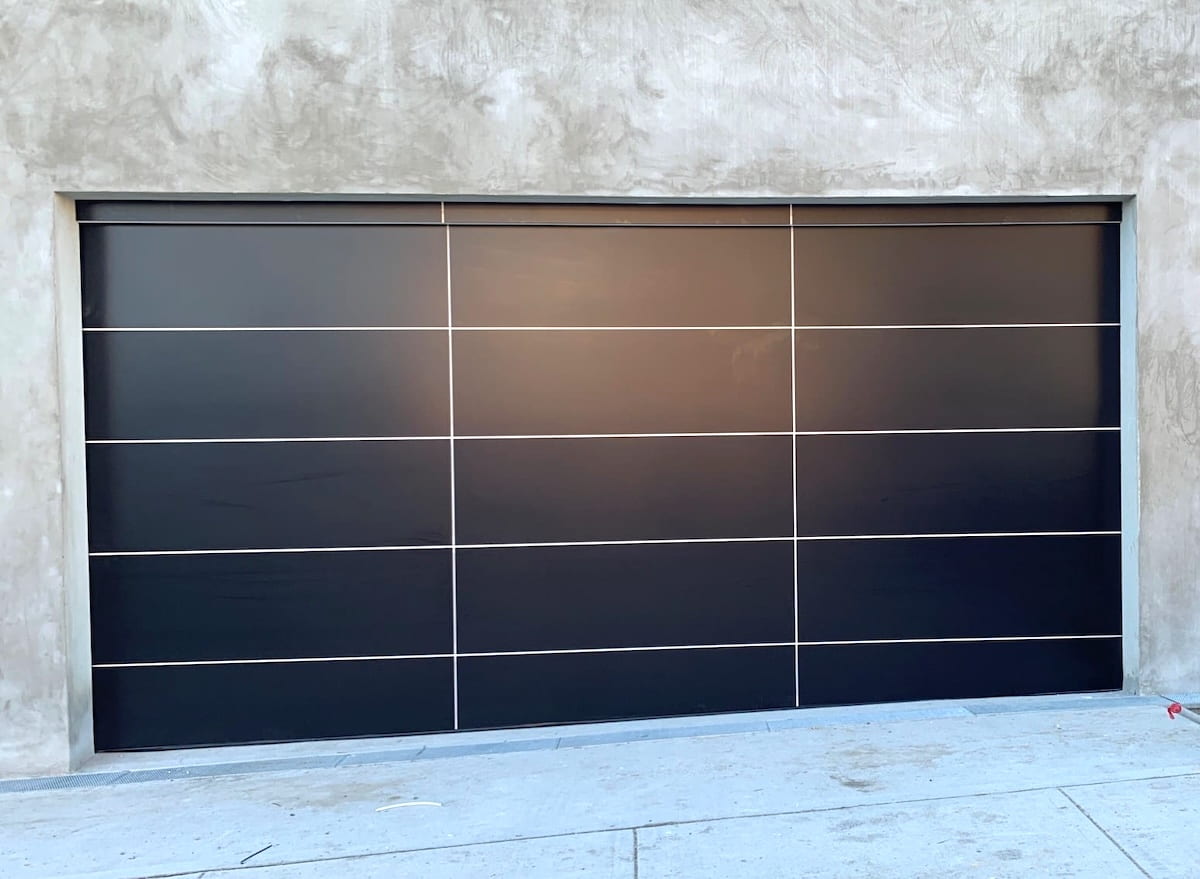 Danmar Alipanel custom sectional garage door featuring Matt Black panels and contrasting Surfmist shadow lines, showcasing architectural design options for modern homes.