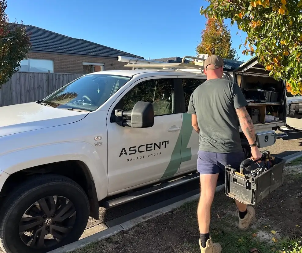 Alec Wilkinson of Ascent Garage Doors carrying his toolbox back to his branded service vehicle after completing a routine residential garage door maintenance service in Geelong.