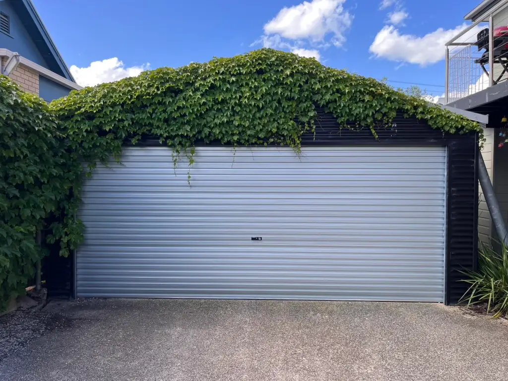 Gliderol double roller garage door in a classic Zincalume finish, framed by green climbing ivy on a property in North Geelong, installed by Ascent Garage Doors.
